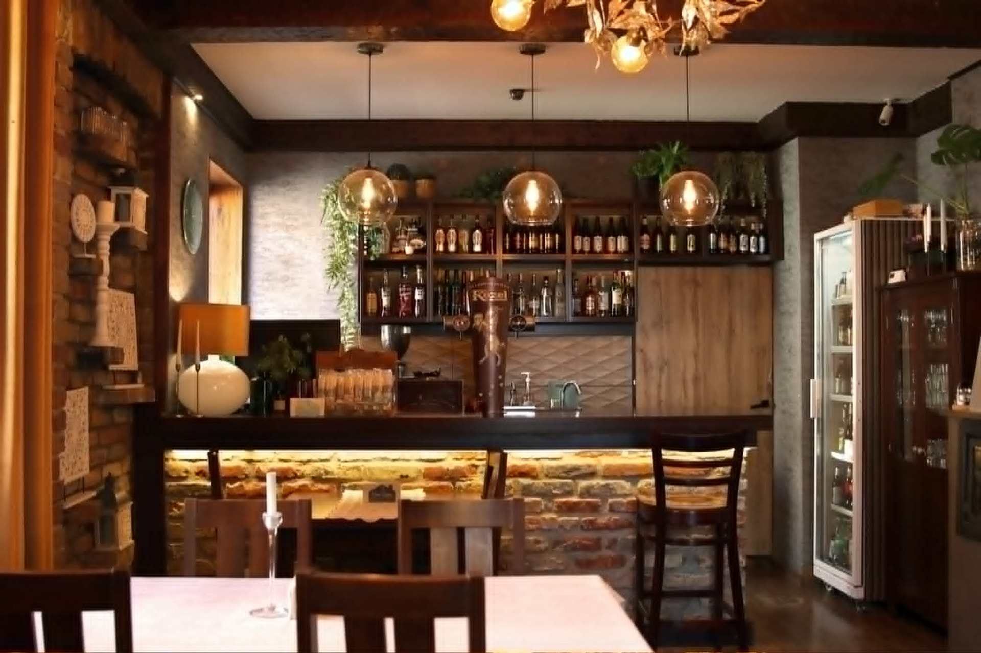 Wnętrze restauracji Stare Bojary w Białymstoku — bar z ceglaną ścianą i ciepłym światłem
