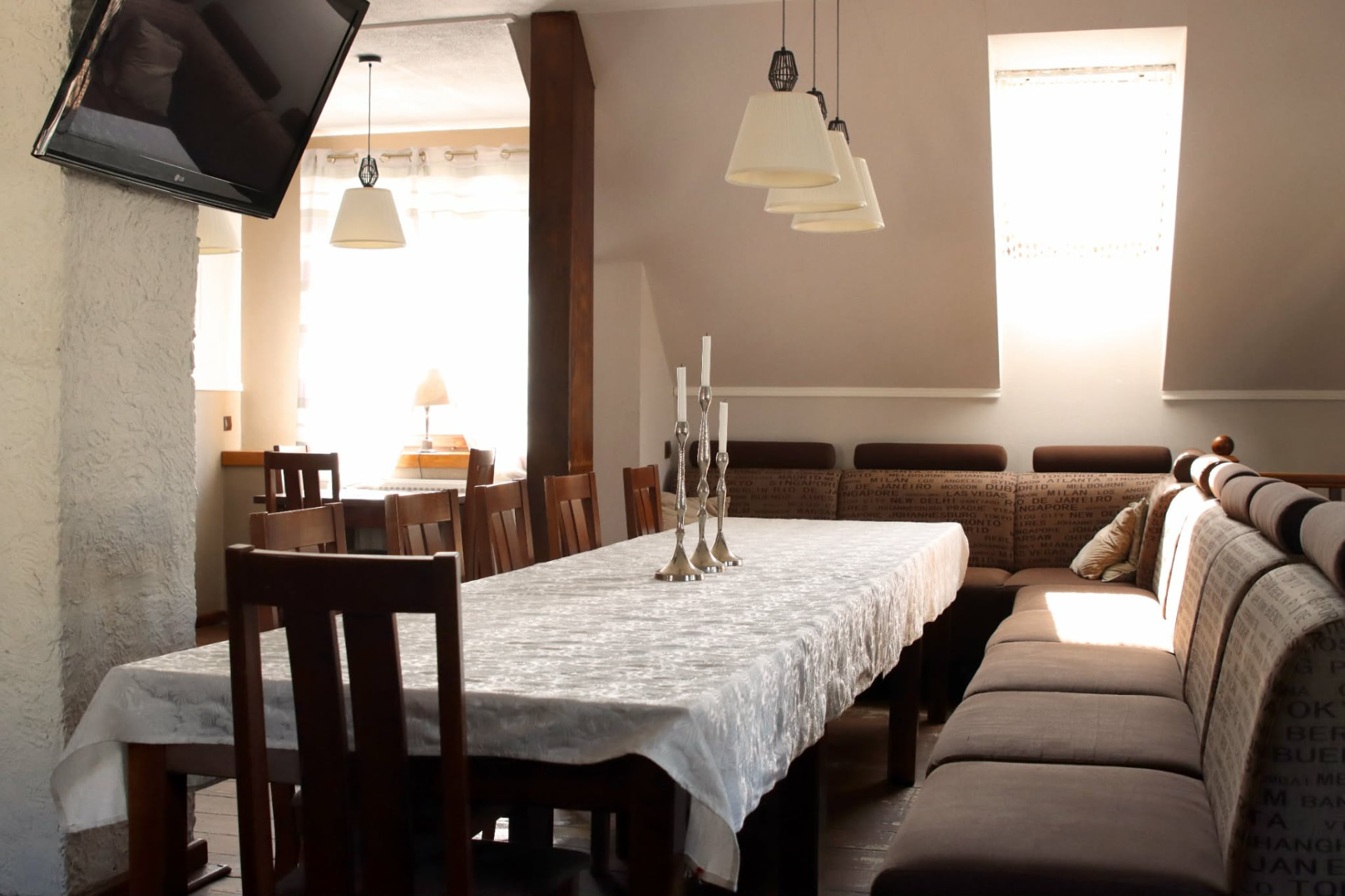 Sala na piętrze restauracji Stare Bojary — przytulne wnętrze z długim stołem, kanapami i świecami
